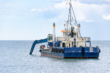 ship with excavator for dredging the entrance to the port