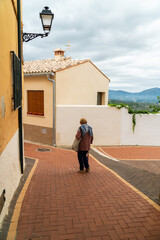 Senior woman walking relaxed on the old town street.