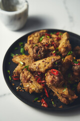 Chinese Salt and Pepper chicken wings. Crispy battered Deep fried chicken wings with vegetables seasoned with salt and pepper and then quickly sauteed with onions, garlic and chilies.
