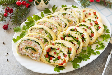Creative appetizers christmas. Cheese rolls with crab sticks, cream cheese, eggs and cream cheese, sweet pepper, greens.