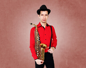 Saxophonist man wearing red shirt holding golden saxophone.