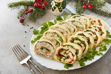 Creative appetizers christmas. Cheese rolls with crab sticks, cream cheese, eggs and cream cheese, sweet pepper, greens. Copy space.