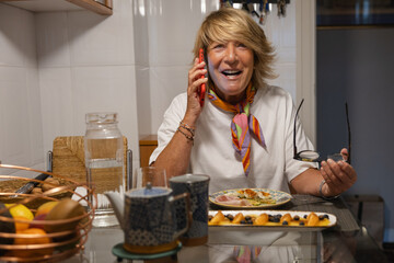 Woman smiling happy talking on the phone while having breakfast © Raquel