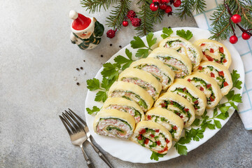 Creative appetizers christmas. Cheese rolls with crab sticks, cream cheese, eggs and cream cheese, sweet pepper, greens. View from above. Copy space.