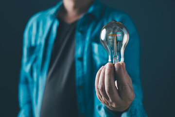 innovation technology success business. person hand holding power lightbulb and pretend to think,...