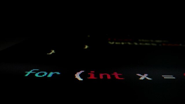 Closeup macro shot movement of coding script moving across LED screen with real-time AI-generated typing, showcasing advanced AI learning in optimization, debug and coding for software development.