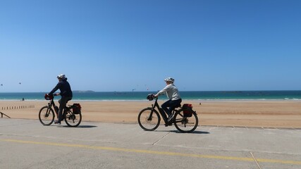 Cyclisme / cyclotourisme à Saint-Malo en Bretagne, deux cyclistes séniors faisant du vélo sur une digue au bord de la mer (France)