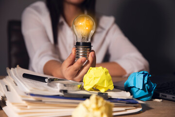 woman holding paper with lightbulbs