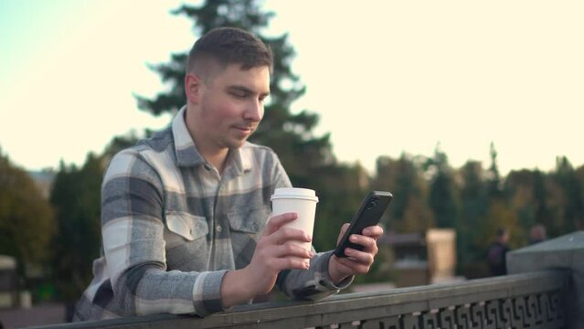 Man is chatting on a smartphone with coffee