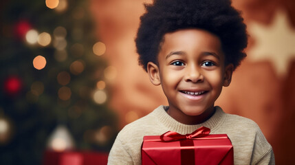 Black african american child with a Christmas present during Christmas time. Little child recieving a Christmas present. Happy child smiling with a present. Christmas background. - obrazy, fototapety, plakaty