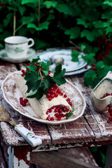 Pavlova roll with red currant in the garden .style vintage