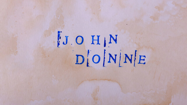 The name of the classic English poet John Donne (1572 &ndash; 1631) is written in stamped letters in dark blue ink on textured aged paper. Good literature, reading list, favorite authors