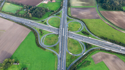 Aerial drone view road junction. Clover roundabout view from above. Car traffic on autobahn Germany. High quality photo