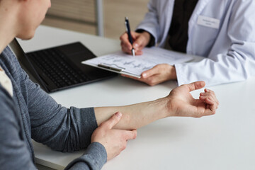 Close up of young man showing skin on forearm during visit to dermatology clinic, copy space