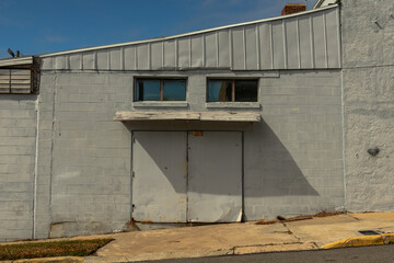 Old abandoned warehouse with double doors and windows in industrial area