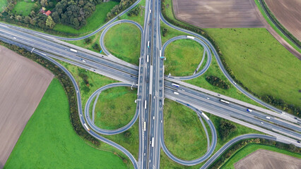 Aerial drone view road junction. Clover roundabout view from above. Car traffic on autobahn Germany.