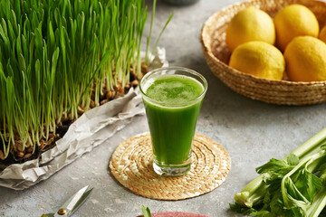 A glass of barley grass juice with fresh barley grass