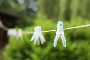Clothespins on a clothesline and a garden background