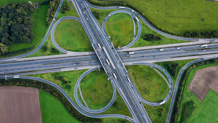 Aerial drone view road junction. Clover roundabout view from above. Car traffic on autobahn Germany.