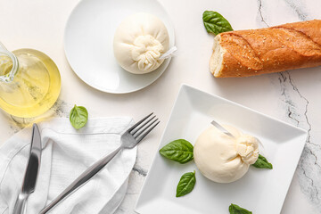 Plates with tasty Burrata cheese on white marble background