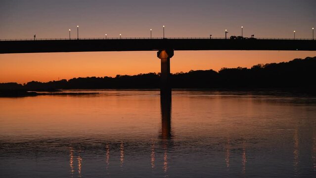 silhouette of a bridge over Missouri River at Hermann, MO, after sunset scenery with car traffic