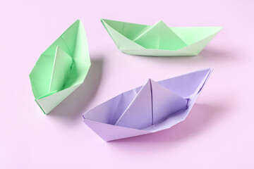 Colorful origami boats on purple background