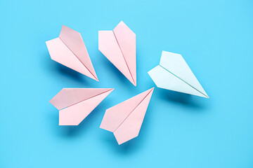 Colorful origami paper planes on blue background