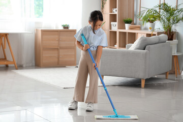 Cute little girl mopping floor at home