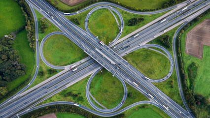 Aerial drone view road junction. Clover roundabout view from above. Car traffic on autobahn Germany.