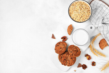 Freshly baked homemade oatmeal cookies with chocolate chips and gluten free nuts with ears on concrete background,modern bakery and grain food concept.Healthy breakfast with ingredients,top view,