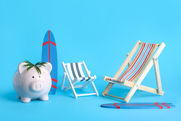 Piggy bank with surfboards and deck chairs on blue background
