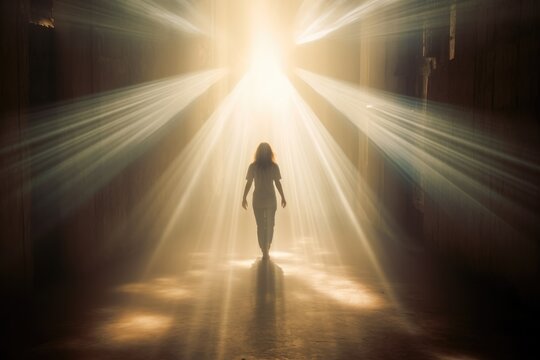 Silhouette of a woman walking towards the light. God's light rays. Full view, back view, rear view. Walking away. 