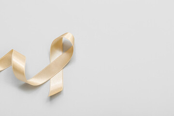 Beige ribbon on light background. Uterine cancer awareness concept