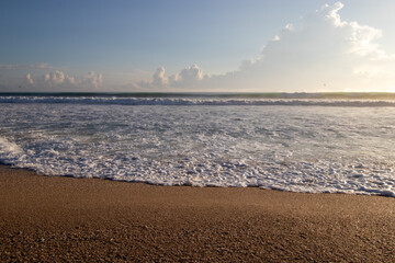 Waves on a sandy beach in the morning