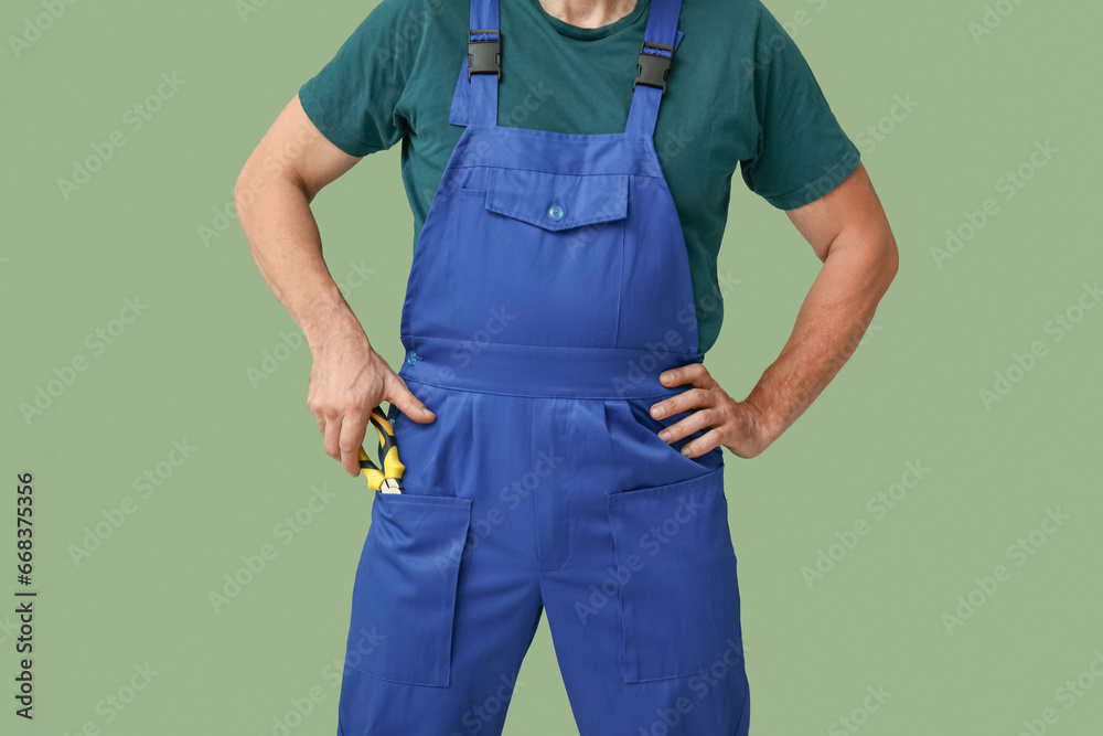 Sticker Male mechanic in uniform on green background