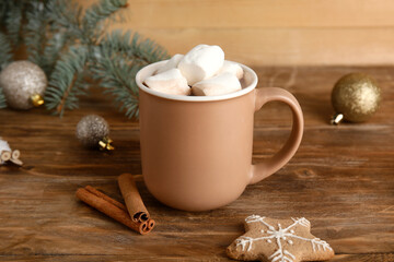 Fototapeta na wymiar Cup of tasty Christmas cocoa with marshmallows, cookie and cinnamon on wooden background