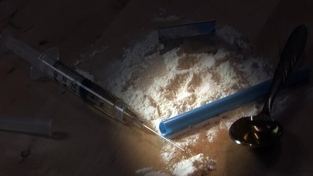 Spotlight moves diagonally across drug paraphernalia