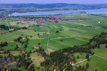 Aerial drone view valley, fields, village, lake at foot of Alpine mountains in Bavaria, Germany.