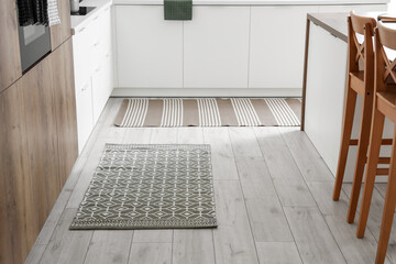 Stylish carpets on floor in kitchen