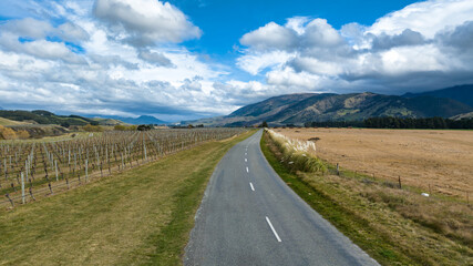 Fototapeta na wymiar Driving on a rural country road through agricultural farmland in a rural valley