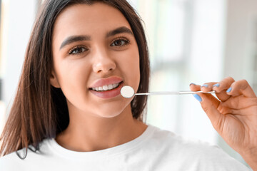 Smiling young woman with dental tool at home, closeup