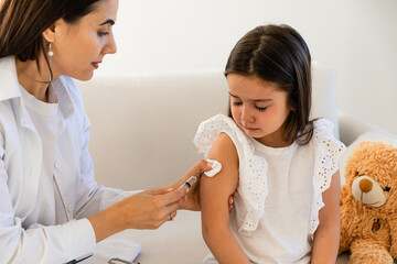 Doctor giving injection to little girl in hospital, closeup. Immunization concept. child is scared...