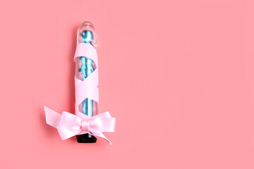Vibrator with bow on pink background