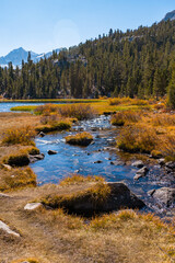 Hiking in Little Lakes Valley in the Eastern Sierra Nevada Mountains outside of Bishop, California. Alpine lakes, fall leaf colors, snow capped mountains and evergreen trees combine to make a pictures