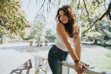 Girl in a city park, enjoying a carefree weekend, soaking up natures beauty, surrounded by a green...