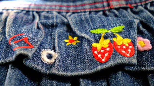 Close up texture of denim fabric. Jeans with cute embroidered. Girls skirt. Wardrobe