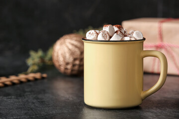 Cup of hot cocoa with marshmallows on black background