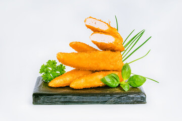 Fast homemade food at home. Breaded chicken nuggets.Breaded Chicken Inner Fillet with green lettuce leaves on a White Background.Chicken Breaded Raw Meat,Fillet.Chicken breaded schnitzels.Fast cooking