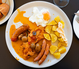 Traditional Spanish stewed tripe with chorizo sausages and mushrooms served with fried sunny side...