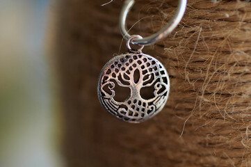 Photo of a silver earring on a textured background.